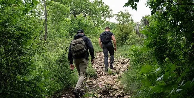 Two men hike up a rocky path