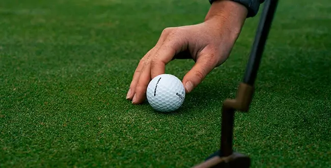 Golfer placing golf ball