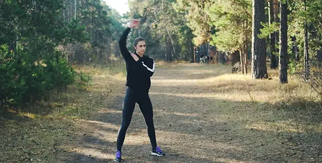 A woman stretching before walking on a trail